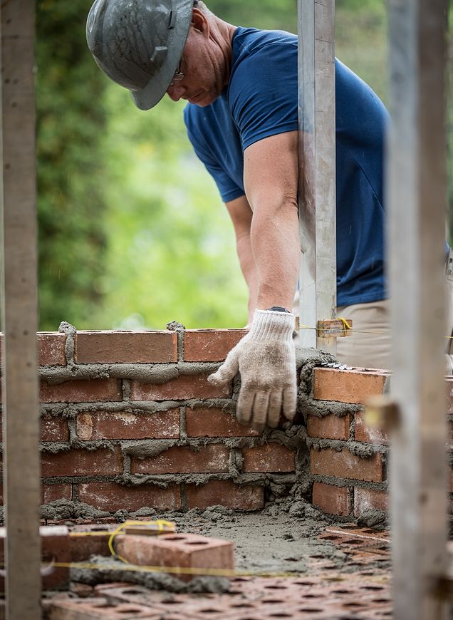 CRH mason laying structural bricks to build a foundation