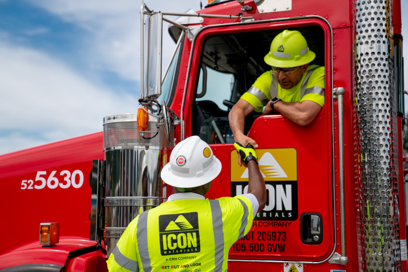 driver shaking hands with other employee from truck window