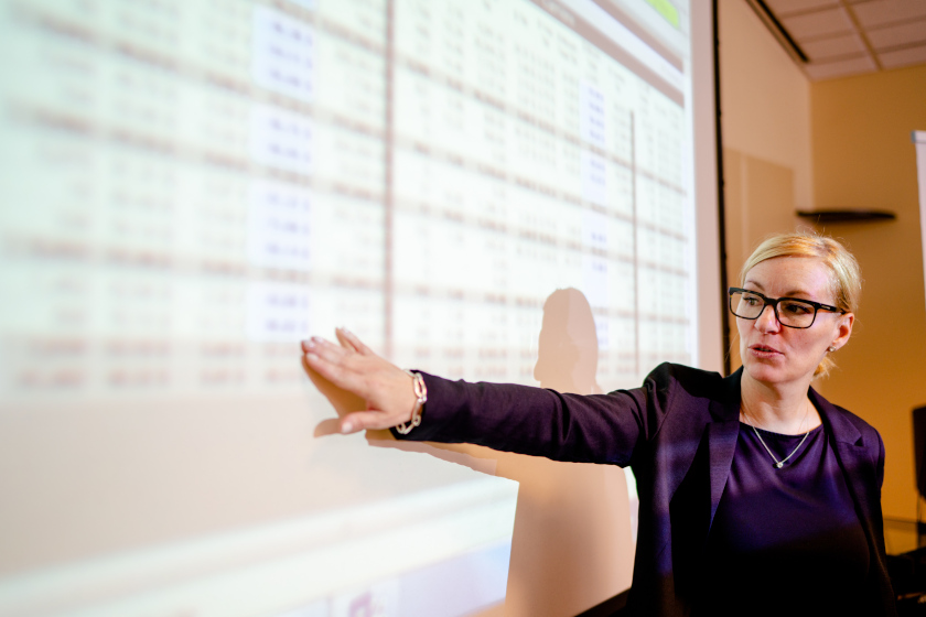 woman gesturing at projected business figures
