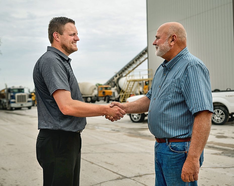 two men shaking hands on work site