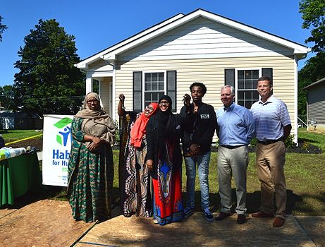 CRH employees posing with community members at a Habitat for Humanity project